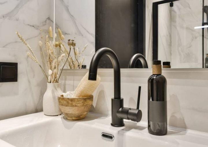 Modern bathroom interior with black faucet and decor.