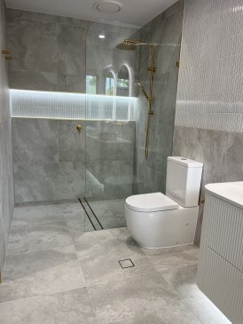 Modern bathroom with glass shower and gold fixtures