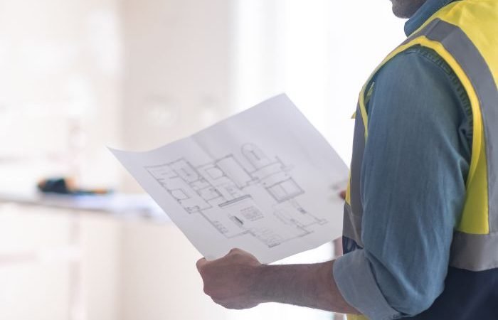Construction worker examining building blueprints