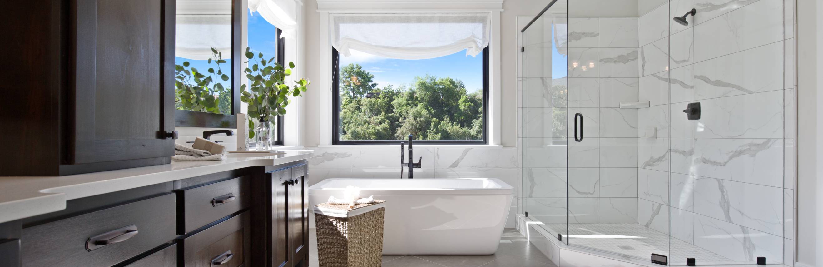 Modern bathroom with bathtub and large window view.