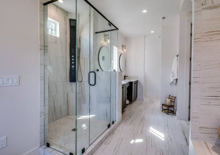 Modern bathroom with glass shower and dual vanities.