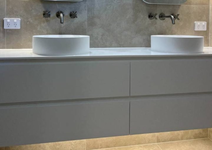 Modern bathroom with double sinks and mirrors.