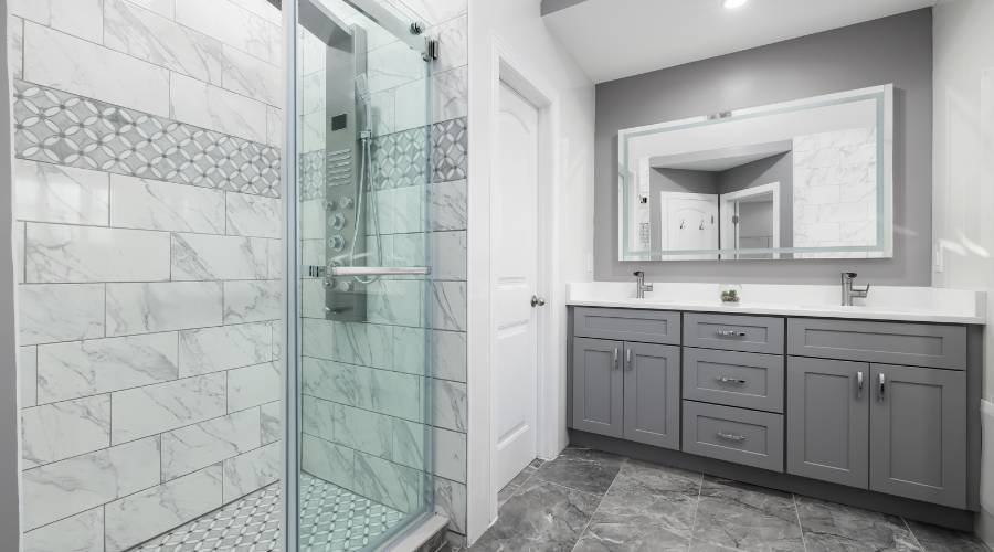 Modern bathroom with glass shower and gray vanity.