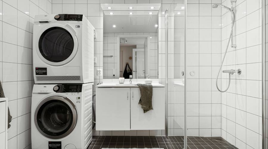 Modern bathroom with washer, dryer, and shower area.