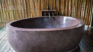 Modern stone bathtub with bamboo background.
