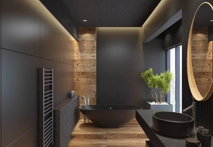 Modern bathroom with dark decor and round mirror.