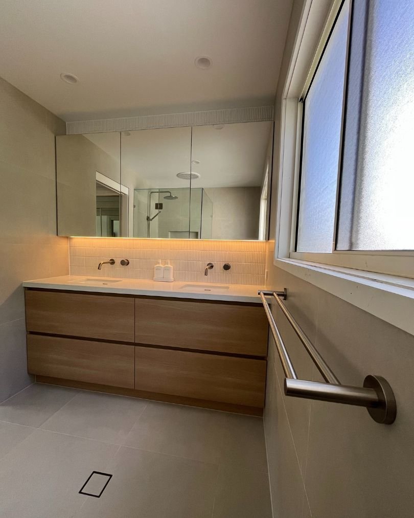 Modern bathroom with double sink and large mirrors.