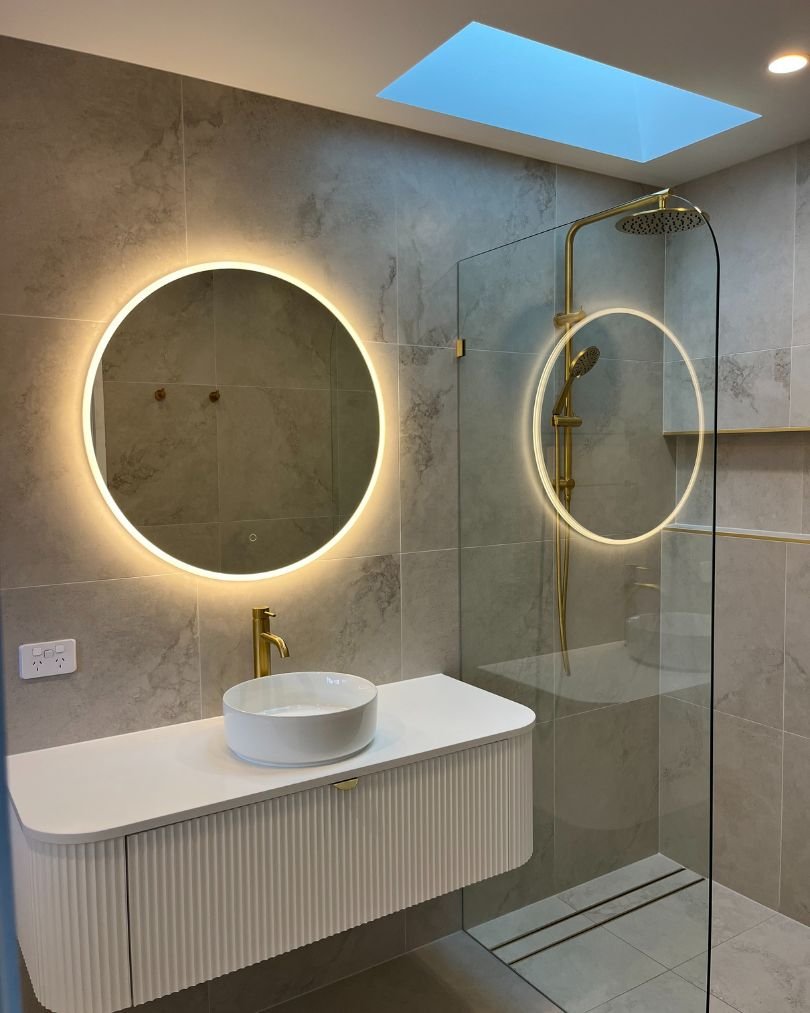 Modern bathroom with illuminated mirror and glass shower