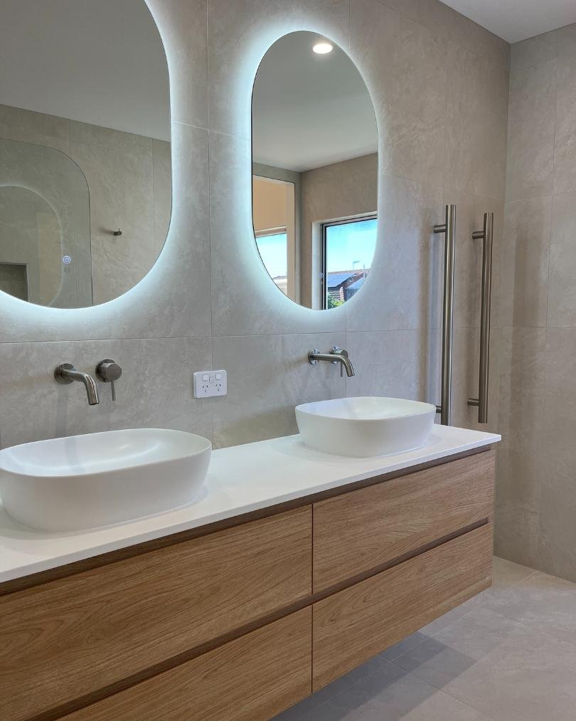 Modern bathroom with double sinks and oval mirrors