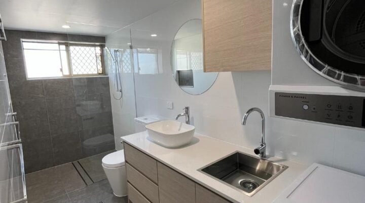 Modern bathroom with washer, dryer, sink, and shower