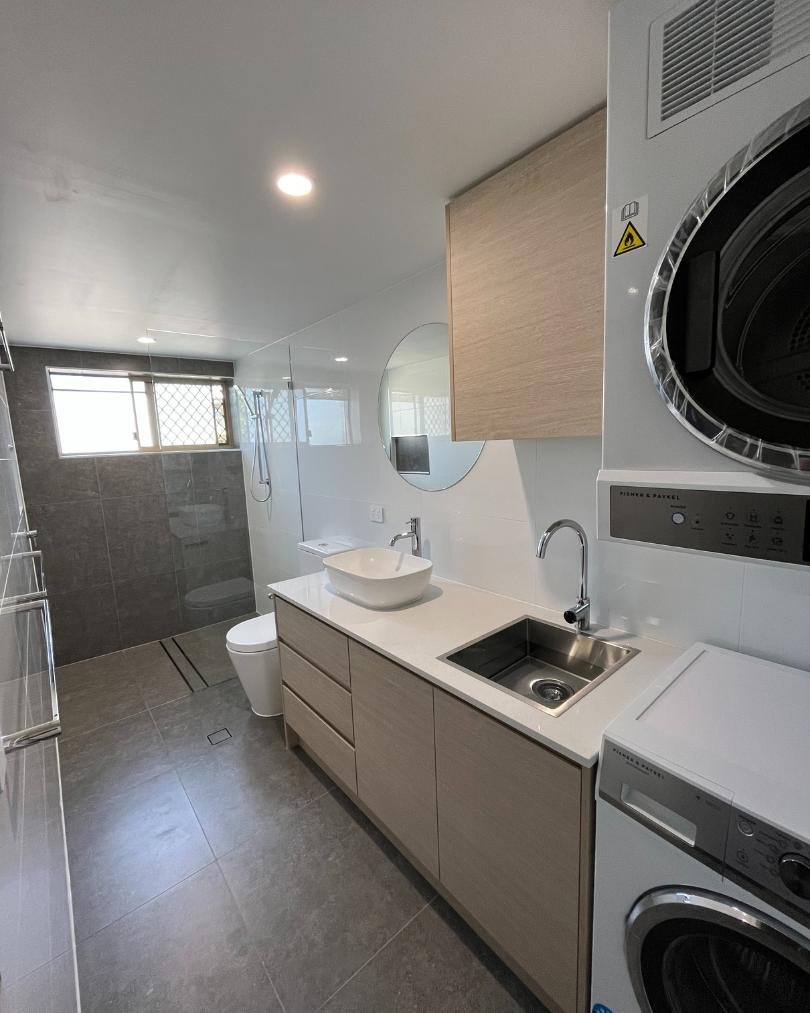 Modern bathroom with washer, dryer, sink, and shower