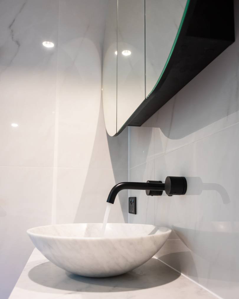 Modern bathroom sink with wall-mounted faucet.